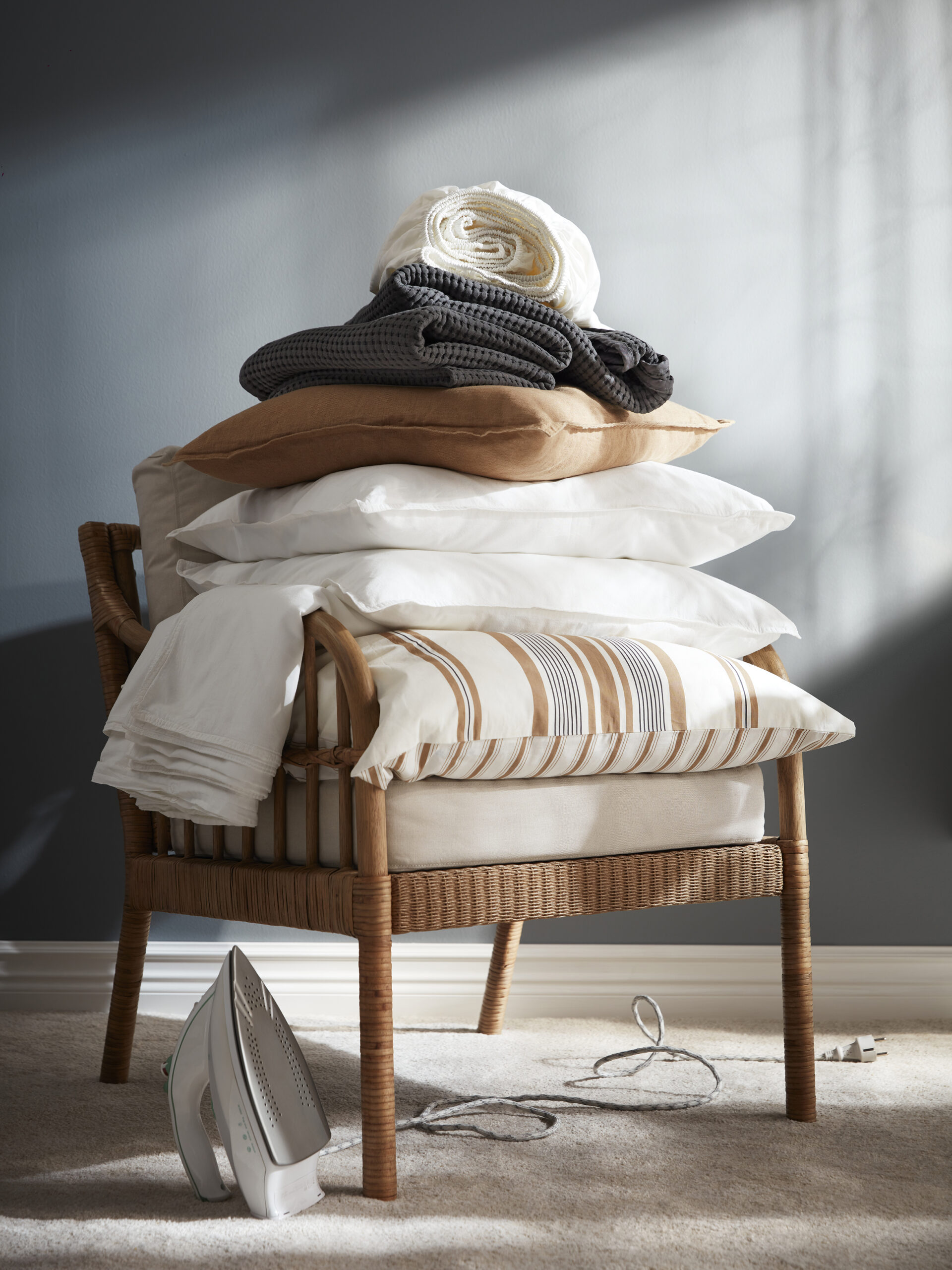 a pile of pillows in a ratten chair
