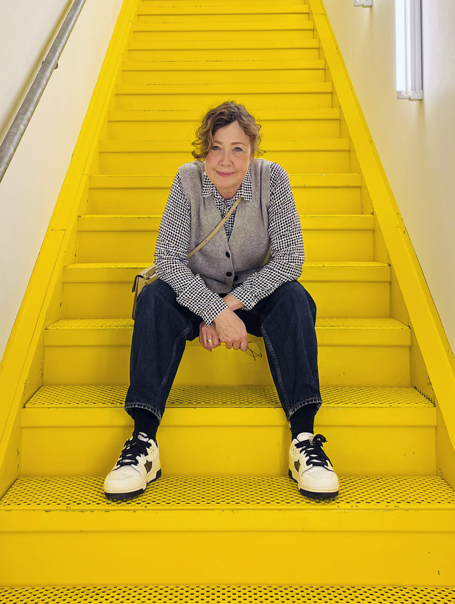 Anja Uddenfeldt is sitting on a yellow stairway